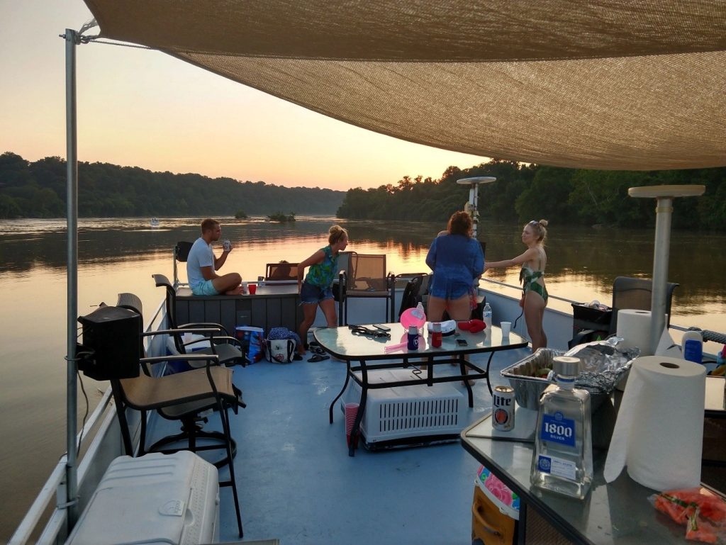 Passengers enjoying a private BYOB boat charter during a Potomac River golden hour sunset
