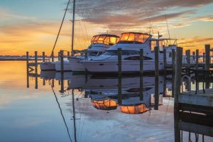 Luxury yachts moored safely in a calm marina during a warm sunset